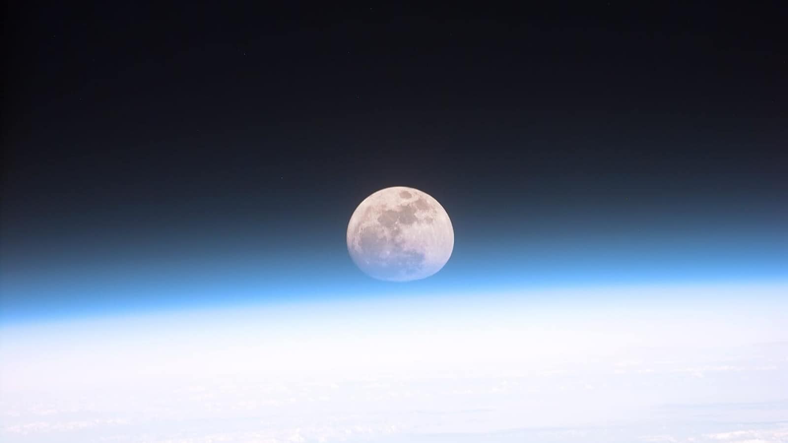 Dünya atmosferinin ardından görünen dolunay (NASA)