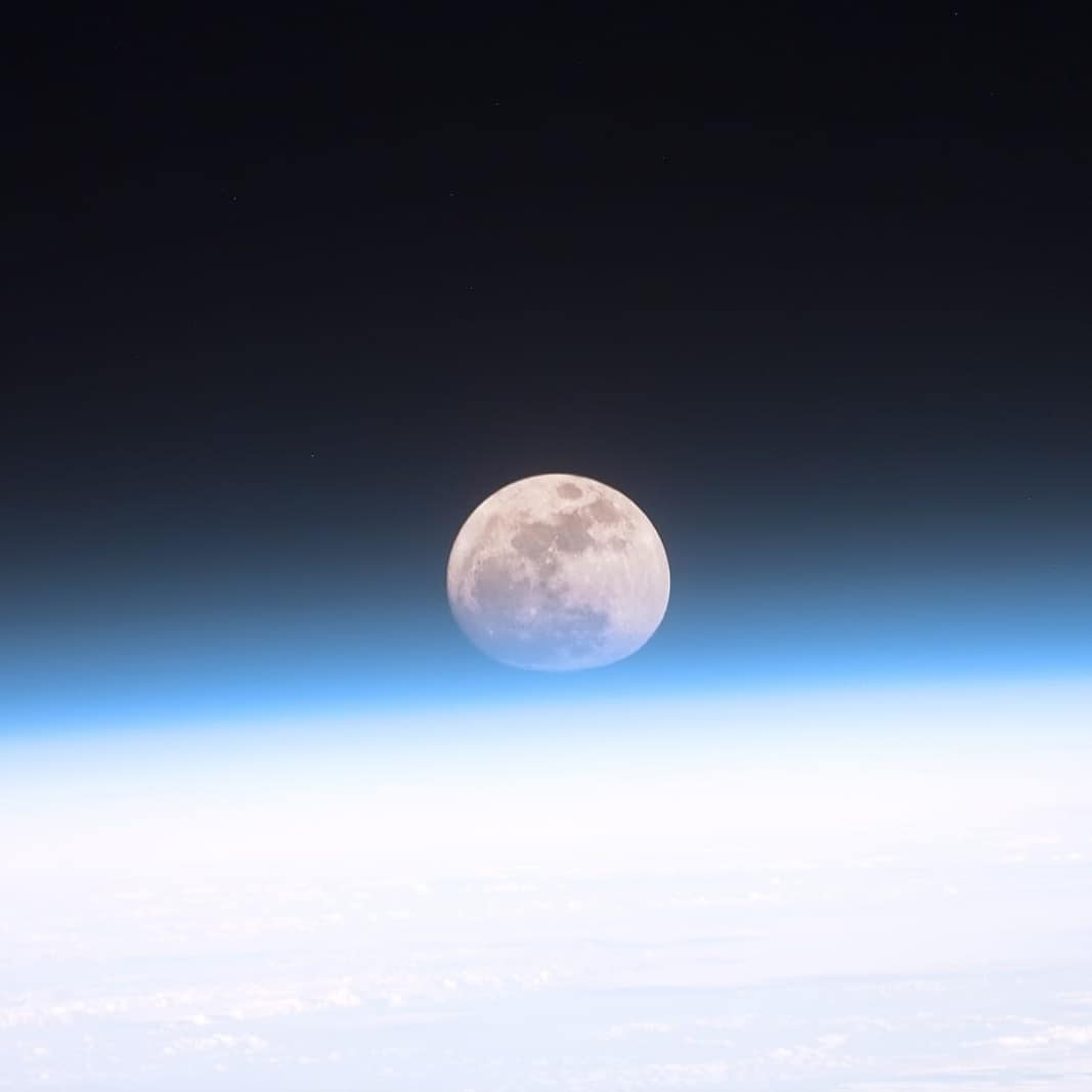 Dünya atmosferinin ardından görünen dolunay (NASA)