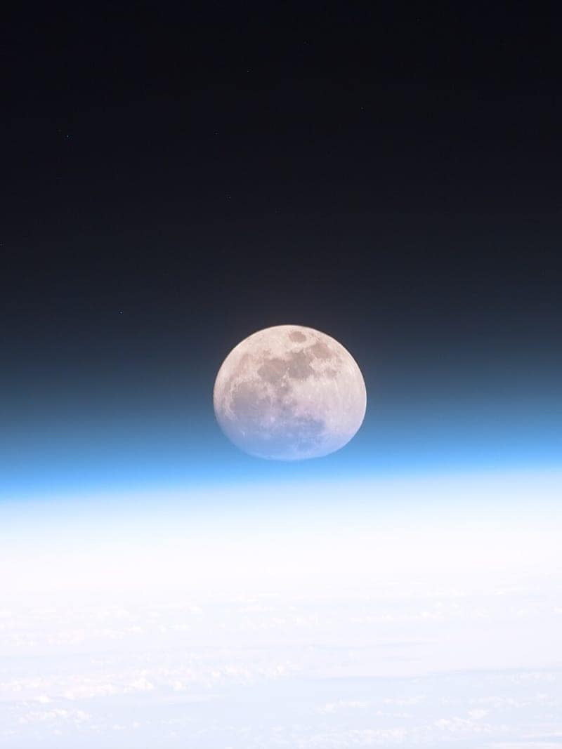 Dünya atmosferinin ardından görünen dolunay (NASA)