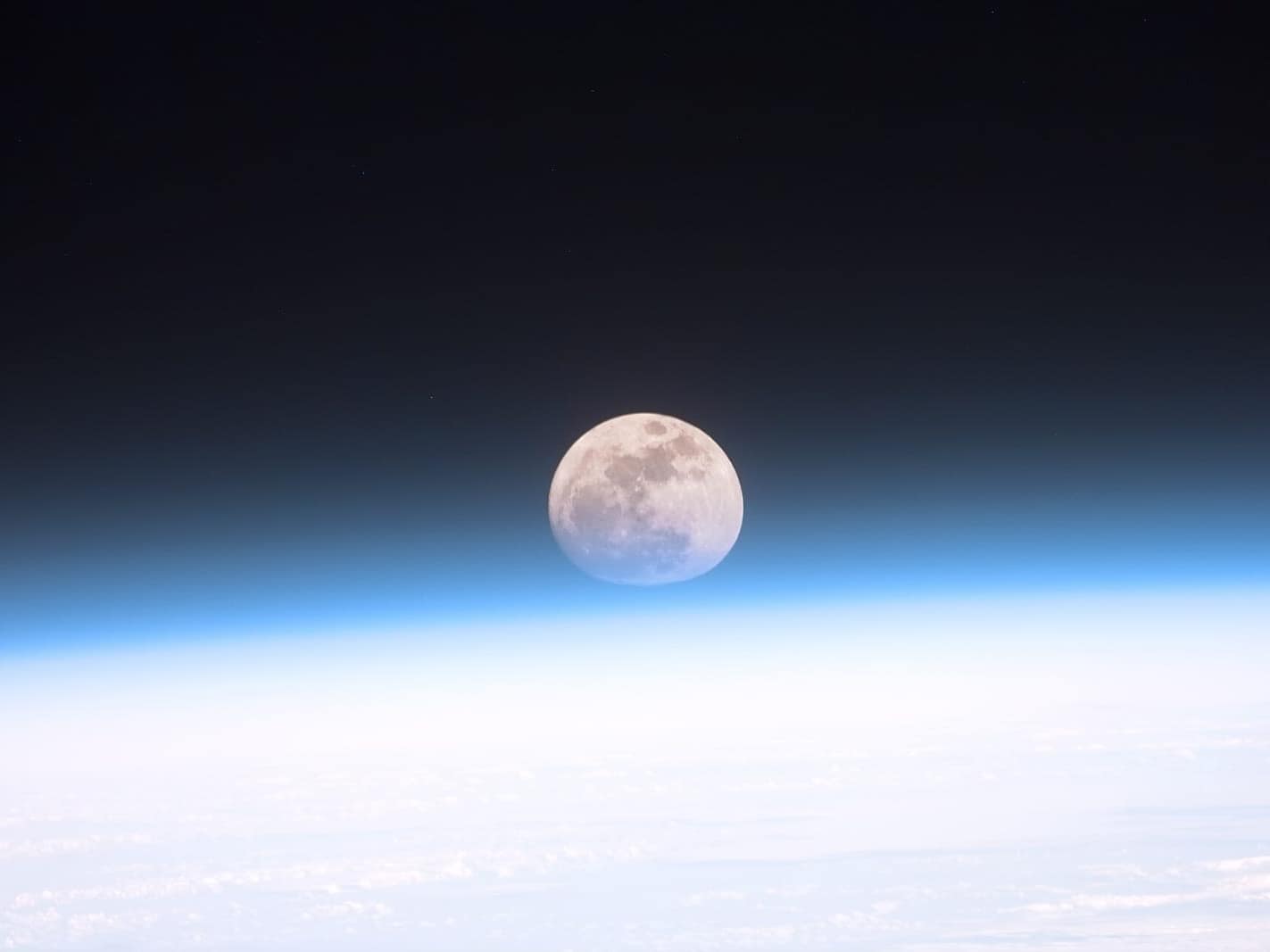 Dünya atmosferinin ardından görünen dolunay (NASA)