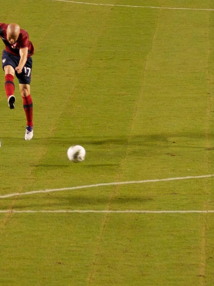 Bir futbolcu ceza sahası dışından şut çekiyor